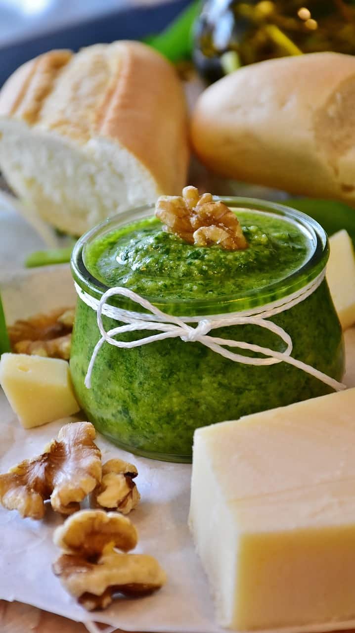 a jar of pesto, cheese and nuts