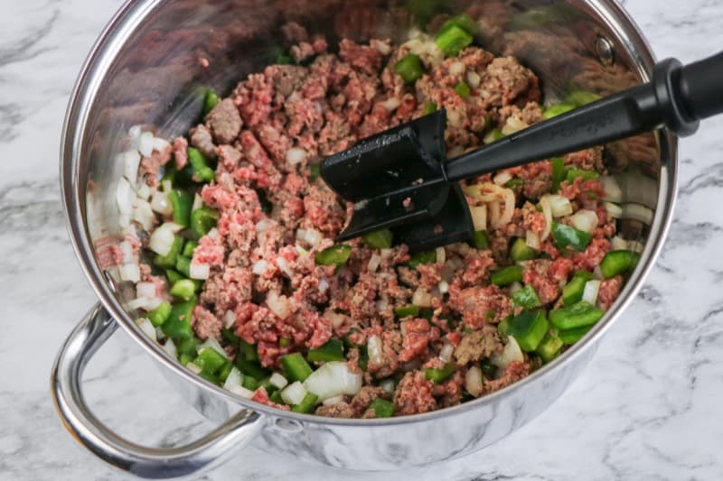 browning ground beef and vegetables in a pan