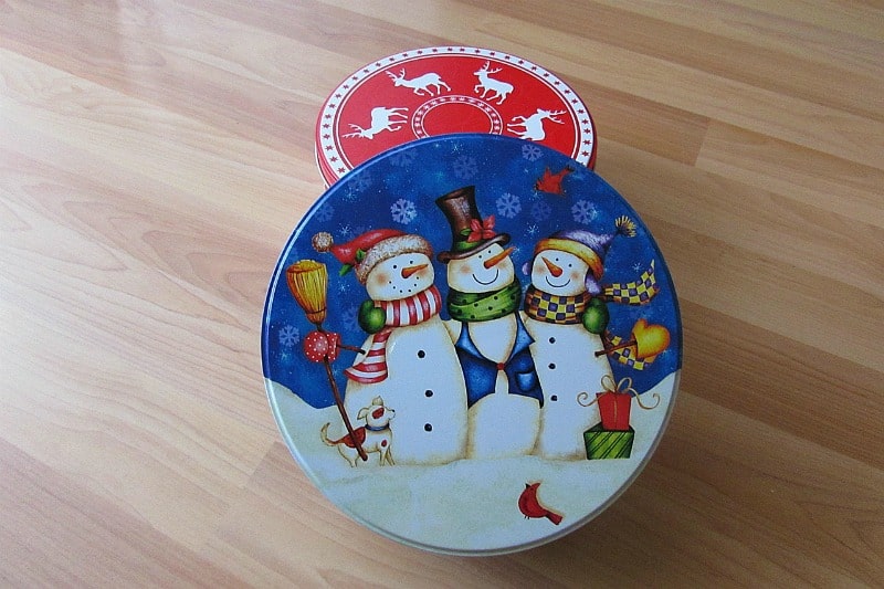 Two Christmas tins filled with chocolate candy