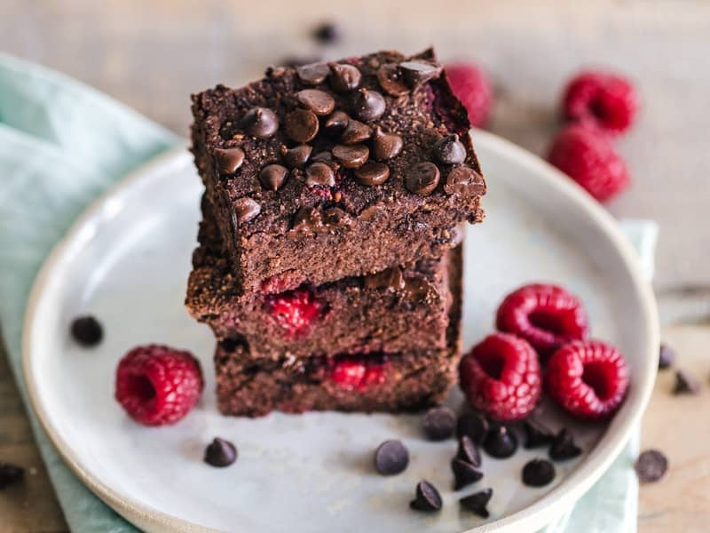 a stack of brownies on a plate with berries