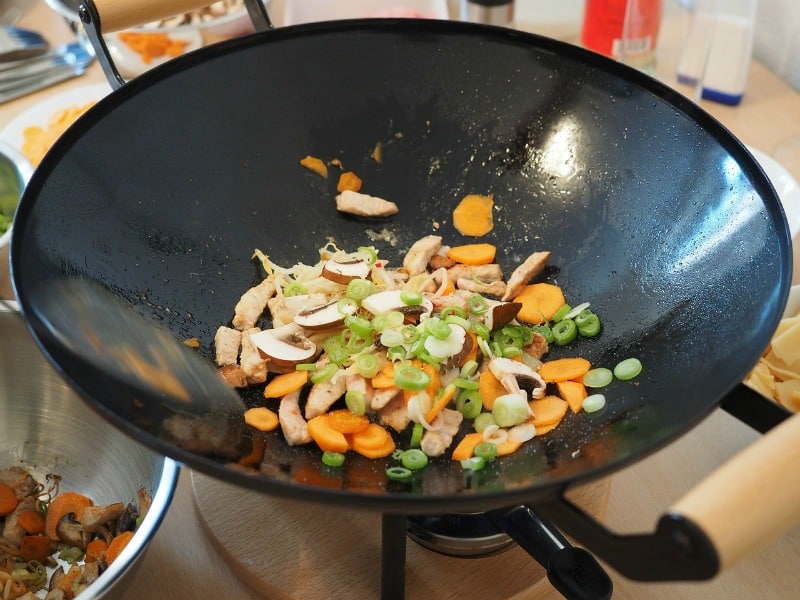 vegetables cooking in a black wok
