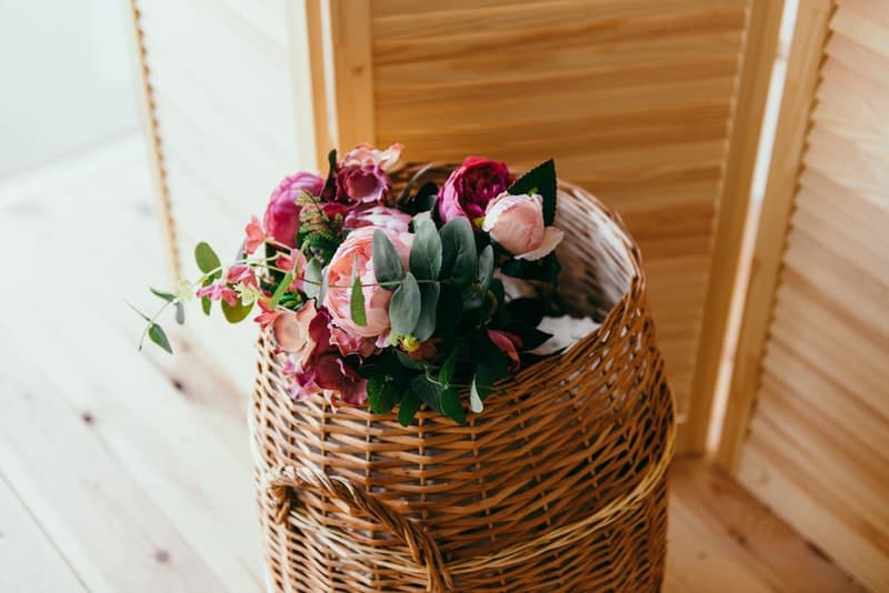 a basket with flowers on top for storage