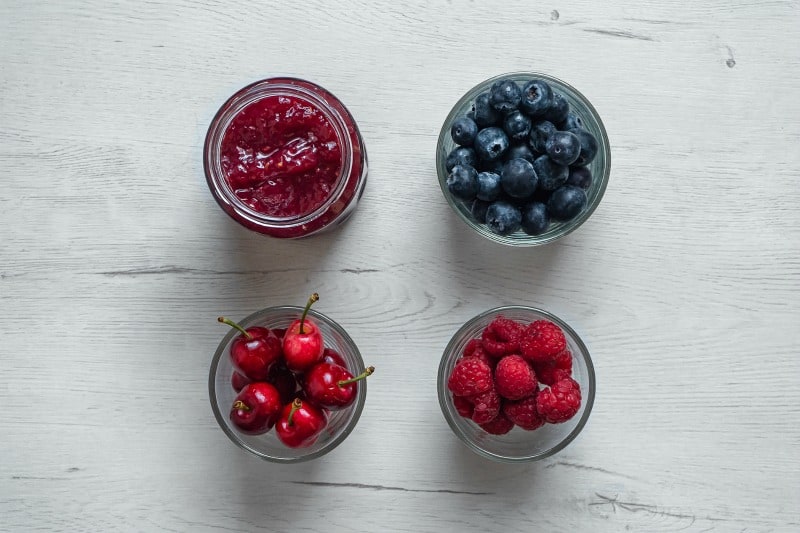 berries and jam in glass bowls