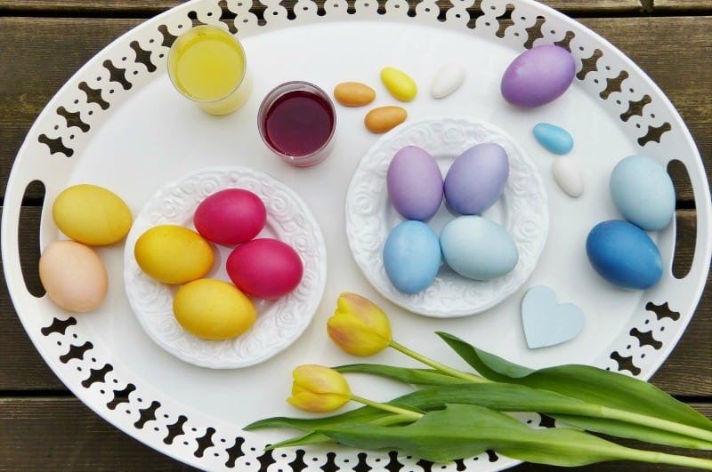 eco friendly Easter eggs on a white platter with tulips