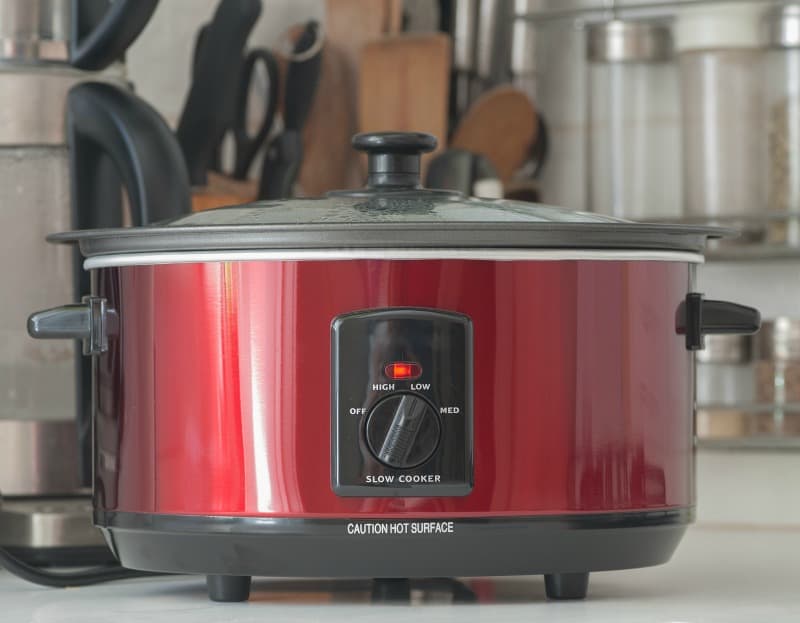 a red slow cooker on the kitchen counter