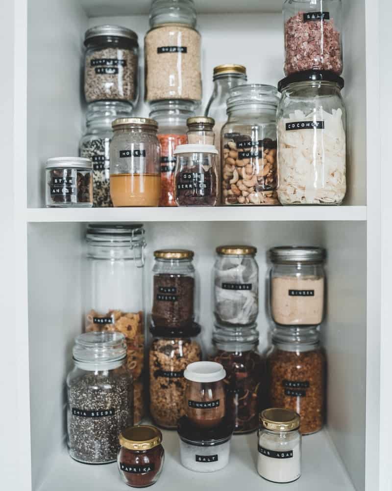a cupboard neatly organized with labeled jars