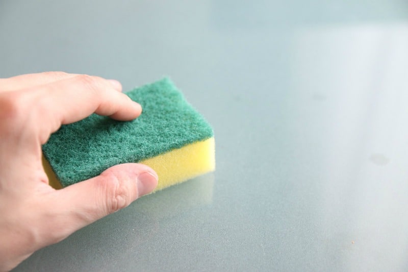 hand holding a green and yellow sponge