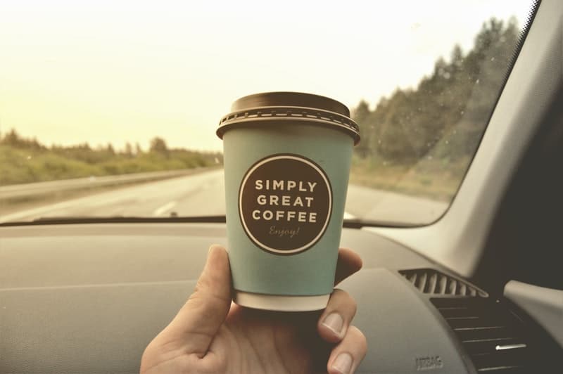 Cup of coffee on a car dashboard