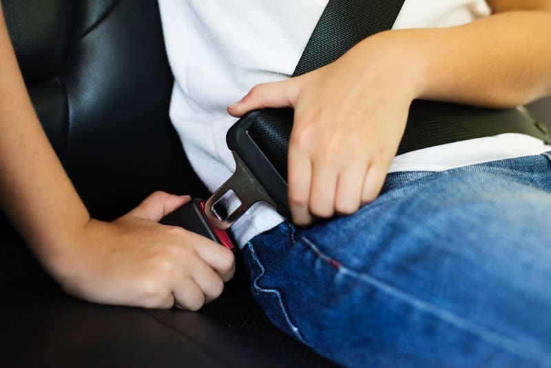 child buckling their seatbelt
