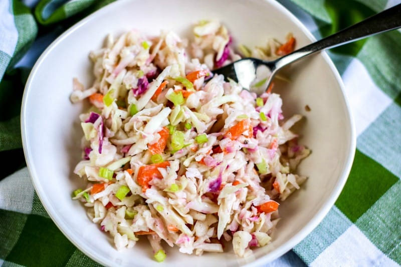 close up of a bowl of coleslaw with a fork