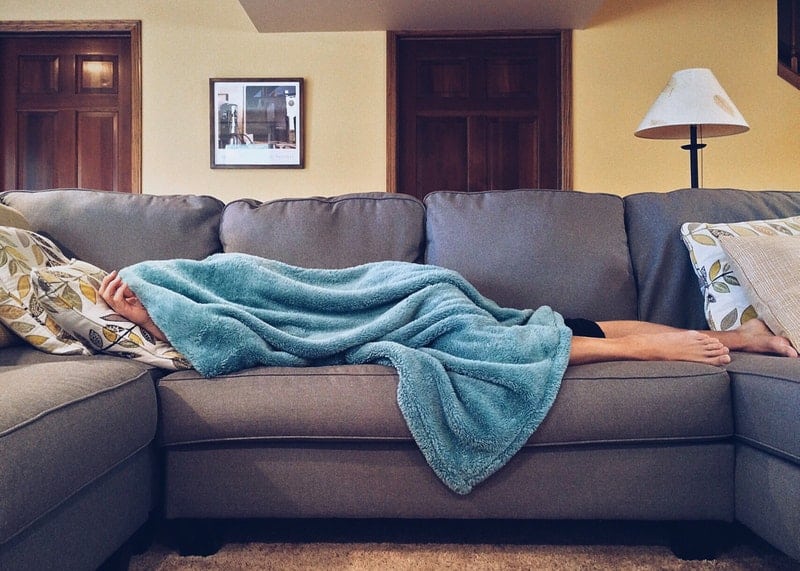 a woman on the couch under a blanket