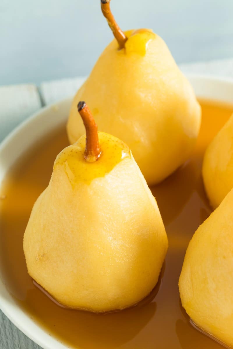 a plate of poached pears in sauce