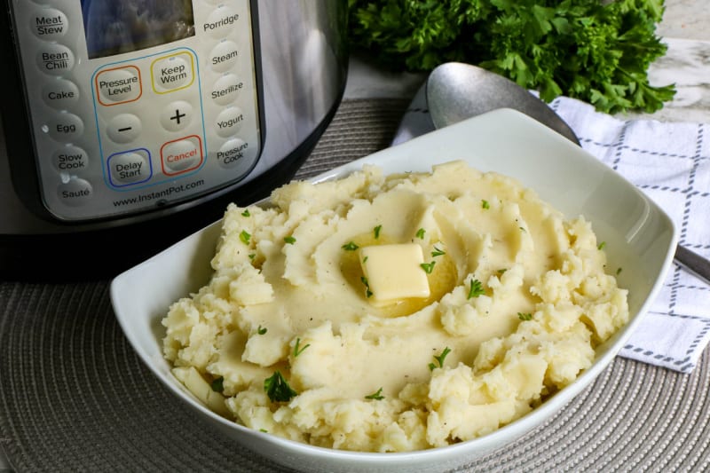 a white bowl full of mashed potatoes with butter melting