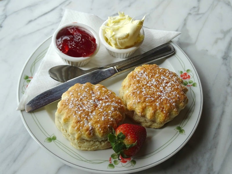 scones butter and jelly on a white plate