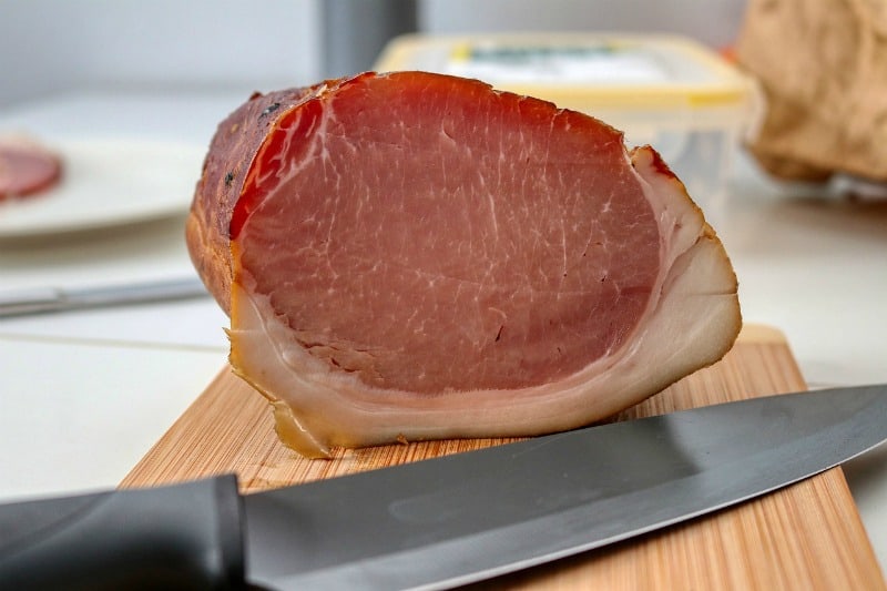 ham on a cutting board with a knife