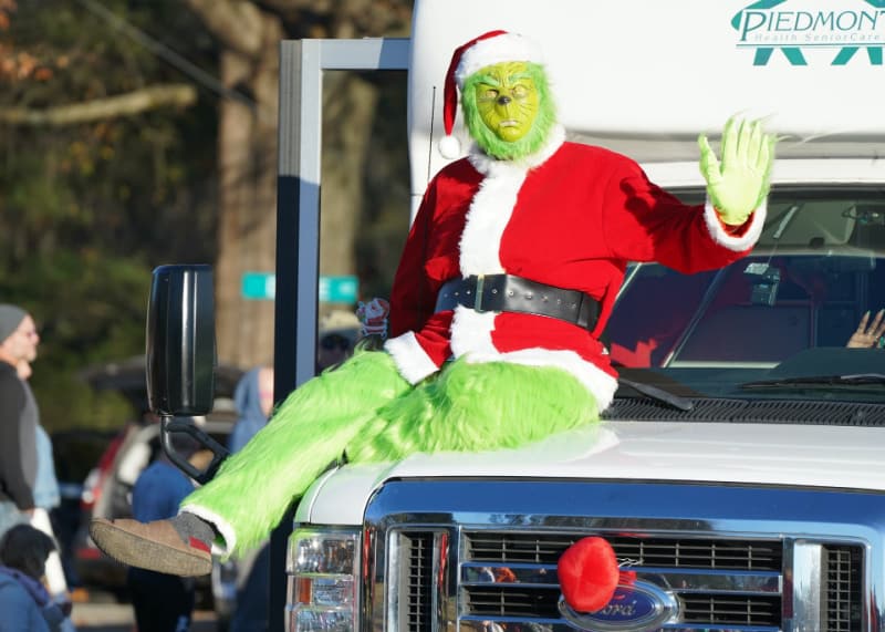 The Grinch waving in a parade