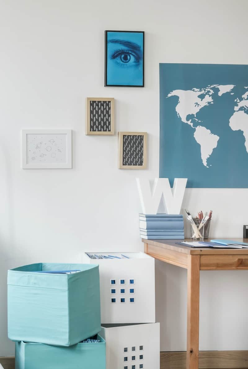 an organized bedroom desk and work area in blue