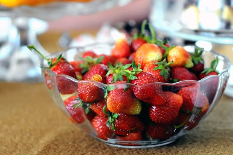 a glass bowl full of strawberries