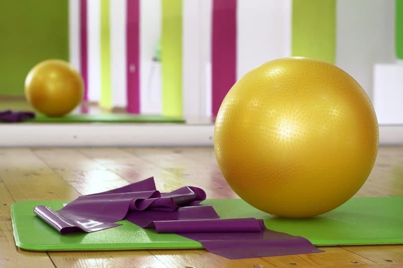 a yellow balance ball on a green yoga mat