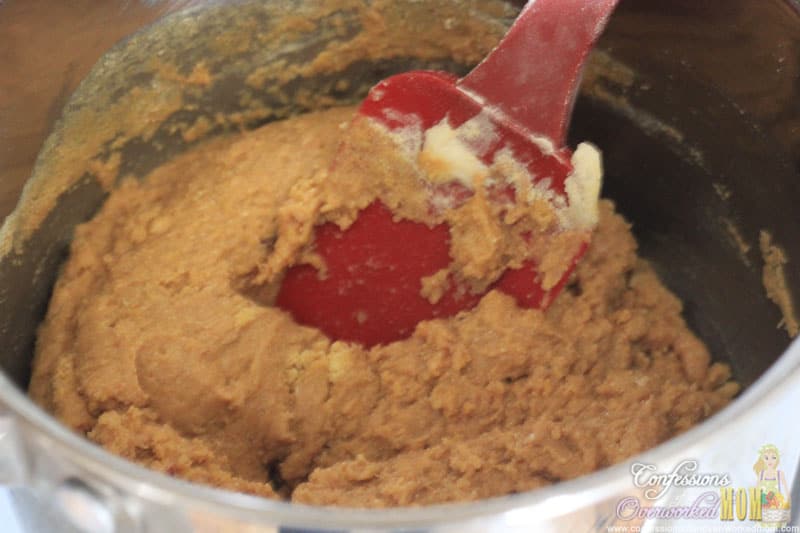 mixing the ingredients in a metal bowl with a red spatula