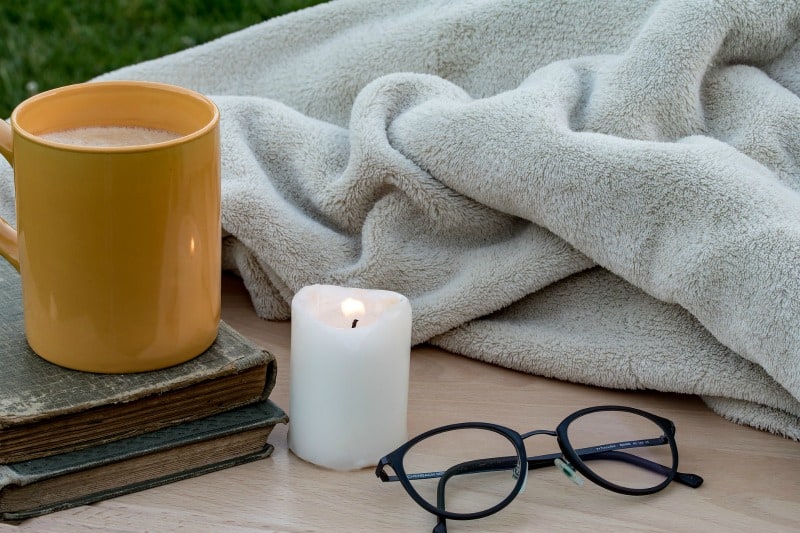 a cup of coffee, a book and a candle
