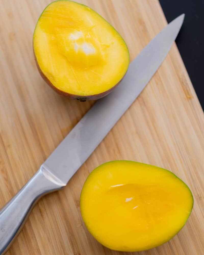 a mango sliced on a cutting board