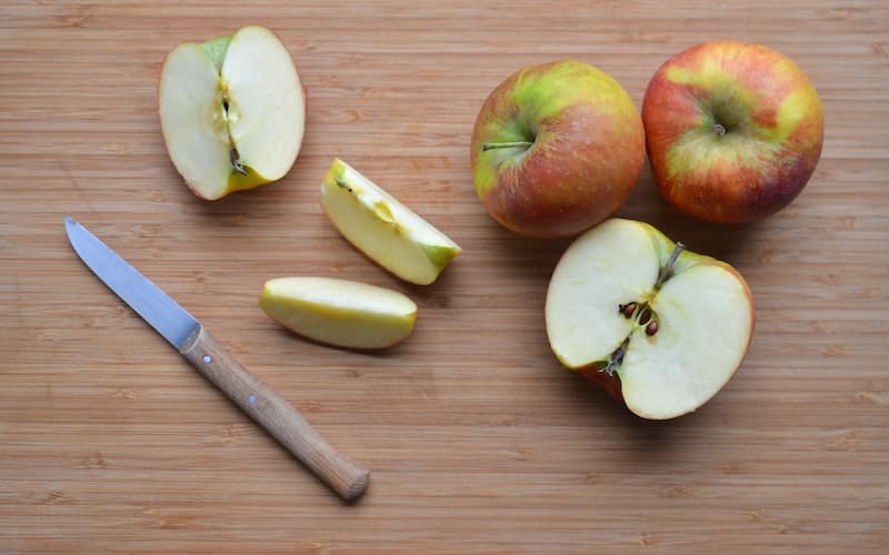 apples being cut on a cutting board