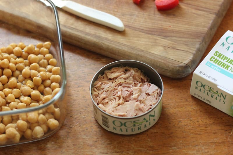 a can of tuna and chick peas on a wooden table