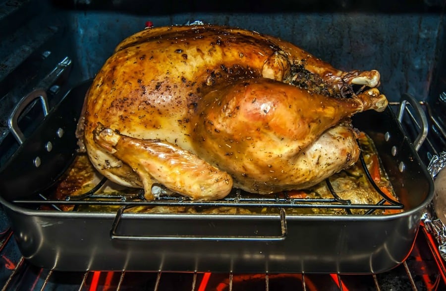 roasting poultry in a black pan in a hot oven
