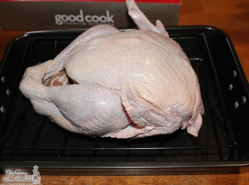 a raw turkey sitting in a roasting pan on the table