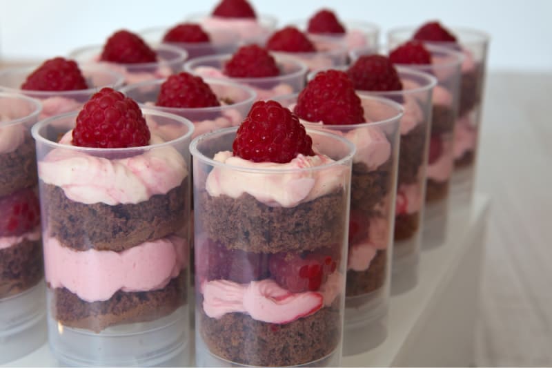 tubes with chocolate cake and pink frosting with raspberries