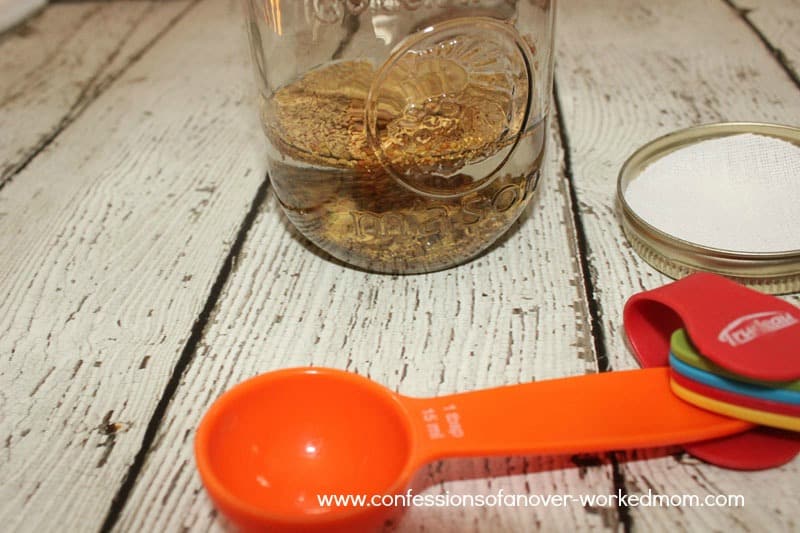 a Mason jar with measuring spoons filled with water and seeds
