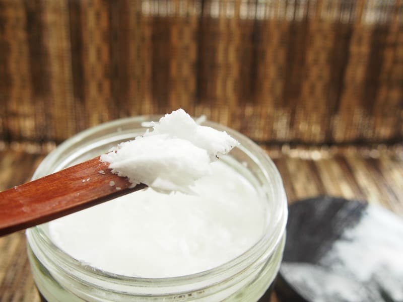 coconut oil in a jar with a wooden spoon