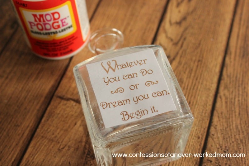 a glass jar with a quote decoupaged on the front