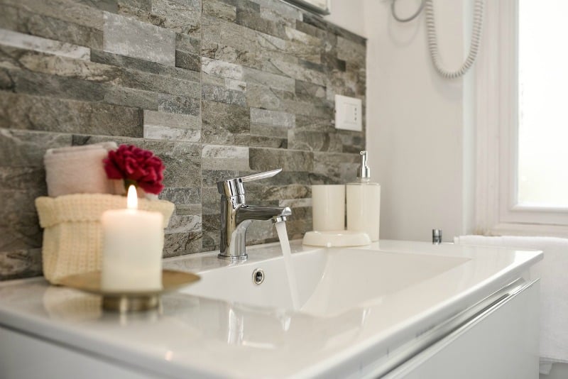 bathroom sink with candle and towels