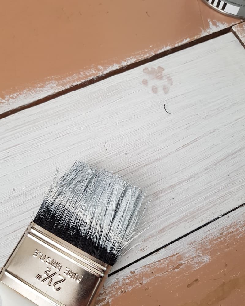 a paint brush on a partially painted table