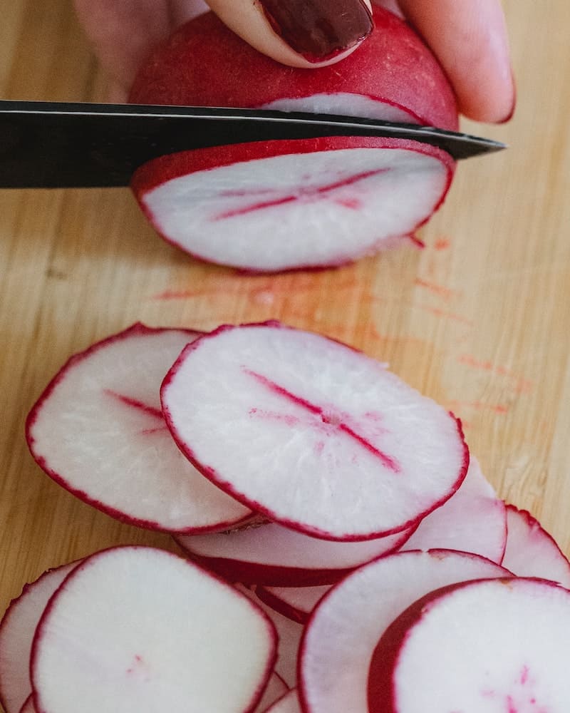 cutting radishes on a cutting board