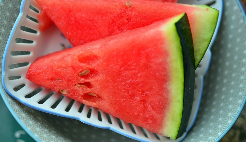 fresh watermelon slices on a blue plate