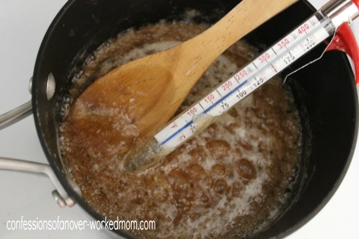 making caramel in a black pot with a candy thermometer