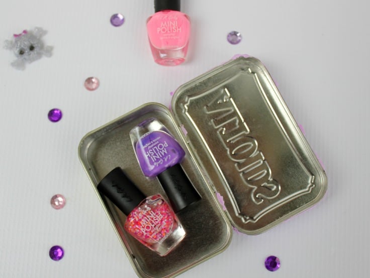 a tin with pink and purple nail polish in it