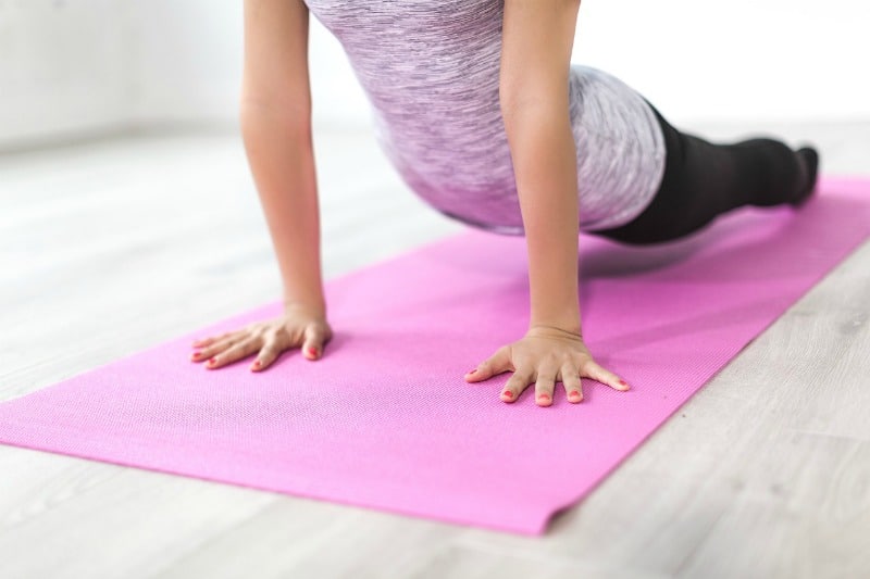 woman doing yoga on pink yoga mat