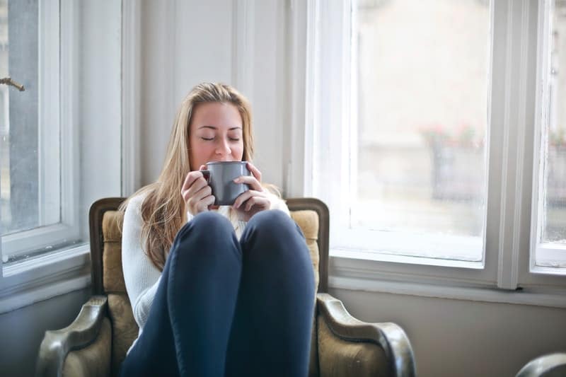 woman holding grey ceramic mug