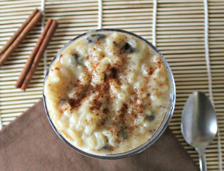 Creamy arroz con leche in a glass cup with cinnamon sticks
