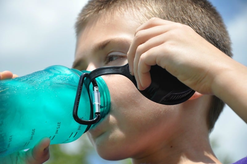 boy drinking from a water bottle