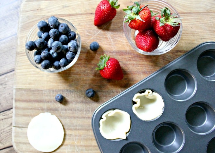 strawberries and blueberries near a mni tart pan