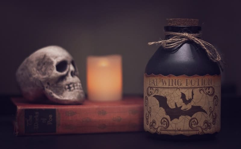a skull, candle and jug on a book
