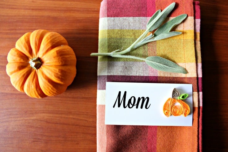 A pumpkin near a napkin with a place card