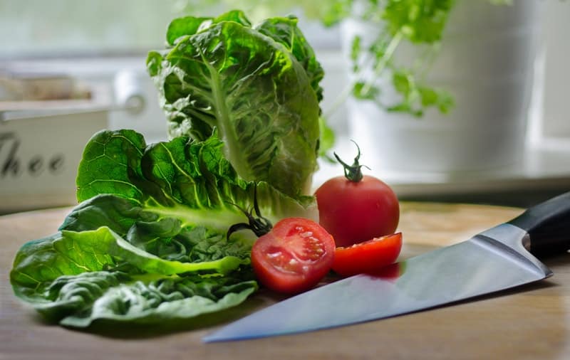 lettuce and tomato on a cutting board
