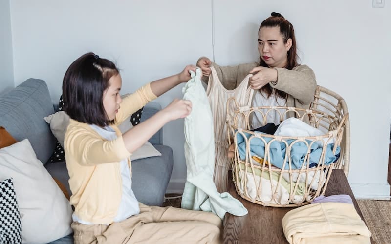 two women folding laundry