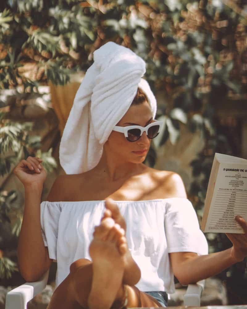 a woman relaxing while reading a book outside